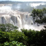 Vista panorâmica das Cataratas do Iguaçu com grande queda de água e vegetação exuberante